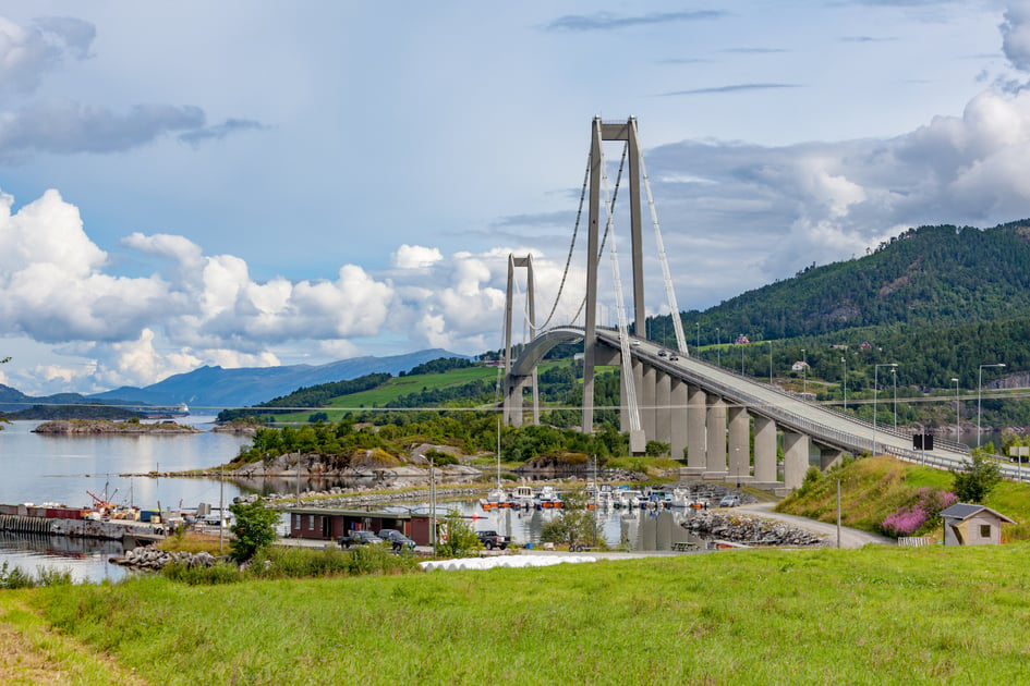 A view of Norway’s Gjemnessund bridge. This concrete-and-steel suspension bridge crosses over a marina and an inlet.